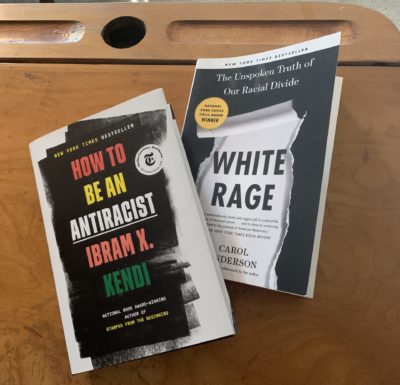 photo showing two books on a school desk, "How to Be an Anti-Racist" by Ibrahim X. Kendi and "White Rage" by Carol Anderson