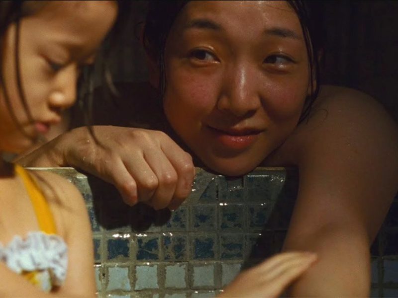 A still image from the film Shoplifters showing a loving mother and child relation.
